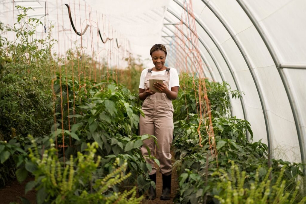 Agriculteur dans un champ cultivé utilisant une tablette près d’un capteur d’humidité du sol pour gérer l’irrigation.